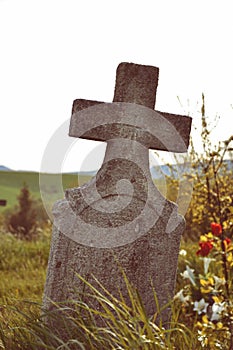 Old grave on traditional European cemetery in Slovakia. Aged cross tomb stone on grave yard in spring