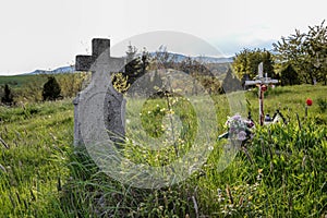 Old grave on traditional European cemetery in Slovakia. Aged cross tomb stone on grave yard in spring