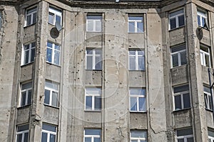 Old gray apartment block wearing the sign of world war II in Warschau.