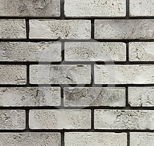 An old, gray brick wall with damage close-up. Background with brick texture