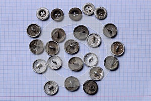 Old gray military buttons lies on white paper