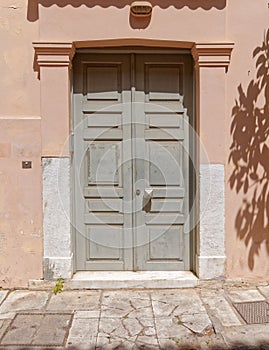 Old gray painted wooden door in old Plaka neighborhood, Athens, Greece.