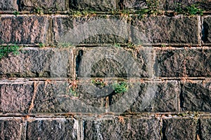 Old gray vintage weathered brick wall texture of ancient castle. Grunge rough block stonewall, masonry structure surface