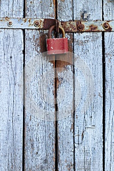 Old gray wooden plank gate with a padlock