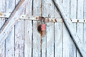 Old gray wooden plank gate with a padlock