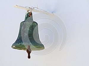 Old greek metal church bell on white wall