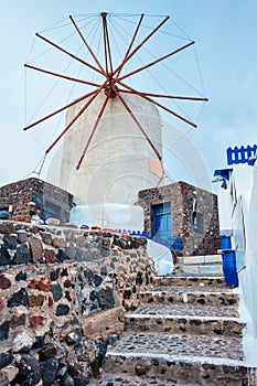 Old greek windmill on Santorini island in Oia town with stairs in street. Santorini, Greece