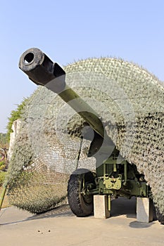 Old green cannon with camouflage