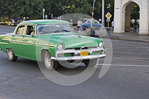 Old Green Classic Car driving by, Havana, Cuba