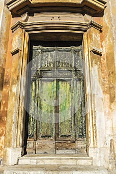 Old green cracked wooden door in a classic building
