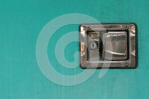 A old green door with a old vintage keyhole stainless steel and padlock, closeup of photo