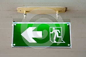 Old Green fire exit sign at hotel.