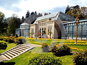 Old green house in beautiful formal garden. in public park with spring flowers in Stuttgart, Germany, Europe