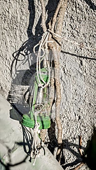 Old green kerosene lamp hanging on a rope on a tree near the wall photo
