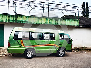 An old green mini bus is parked waiting for passengers