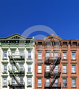 Old green and red apartment buildings with empty clear blue sky background in the Alphabet City neighborhood of Manhattan in New
