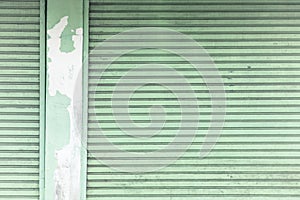 Old green roller shutter door with pole.