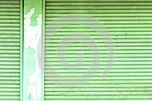 Old green roller shutter door with pole.