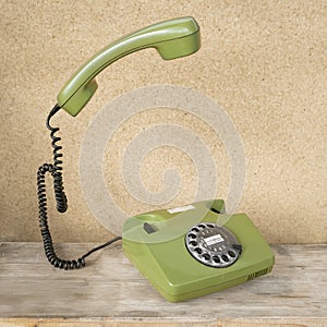 Old green Rotary Telephone with Disc Dial, phone handset levitates, flies in air, Secure Communication, Obsolete Technology, Retro