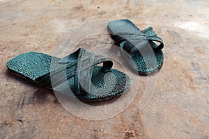 Old green rubber shoes on dirty cement ground for background