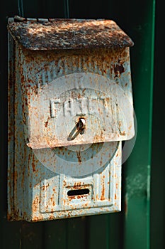 An old green rusty russian postbox with a caption on the metal - for the papes. It is placed on a green metal fence