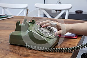 Old green vintage telephone on the table