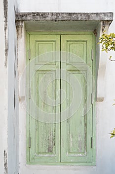 Old green window on classic house wall background