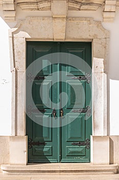 Old green wooden door in house facade