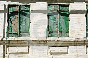 Old green wooden window shutters of rustic house