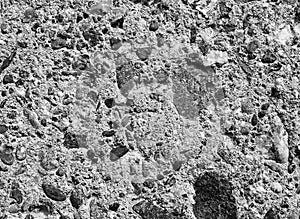 Old grey concrete wall with pieces of stones and cobbles background texture, gray weathered cement wall with pebble texture,