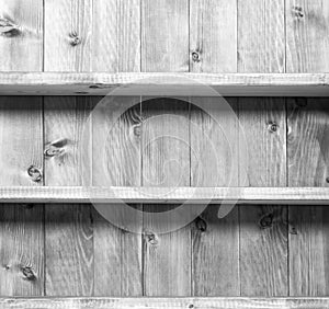 Old grey empty book sheves on wooden wall