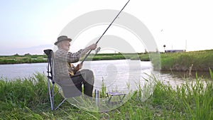 old grey-haired man catching fish. Retirement fishery