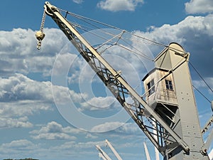 old grey historical crane in genova harbouragainst blue sky photo