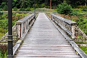 An old grey moss covered boardwalk with rails