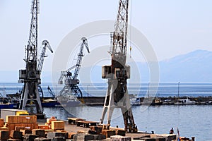 Old grey port cranes and small ships, harbor of Rijeka, Croatia