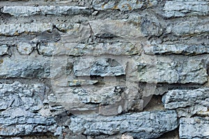 Old grey rough stone wall close-up texture background, selective focus, shallow DOF