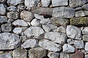 Old grey rough uneven stone wall background