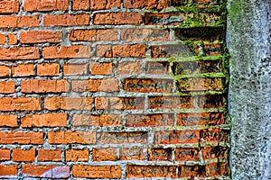 Old grunge red brick wall with concrete wall and moss, texture o