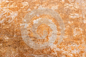 old grunge, rough and weathered pale orange stone wall with visible cracks close up background