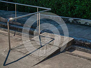Old grunge wheelchair ramp with metal bar