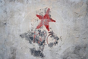 Communistic symbol: Grungy red star graffiti on and old wall