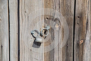 Old grungy padlock on a wooden door, wood background, closed door