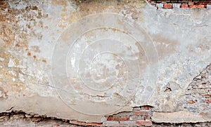 Old grungy red brick wall with peeled beige stucco background. Vintage retro plaster wall with dirty cracked scratched