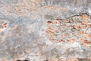 Old grungy red brick wall with peeled white beige stucco background. Vintage retro plaster wall with dirty cracked