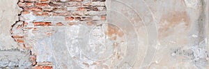 Old grungy red brick wall with peeled white beige stucco banner background. Vintage retro plaster wall with dirty