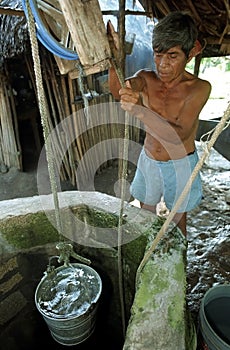 Old Guatemalan Indian man gets water from well