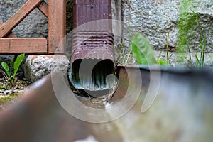 An old gutter in a detached house. Rainwater drainage from the roof