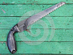 Old hack-saw on wooden background
