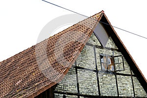 Old half-timbered barn. Weathered building with an old open window