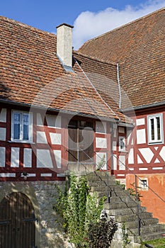 Old half-timbered house with stone stairs leading to a wooden door